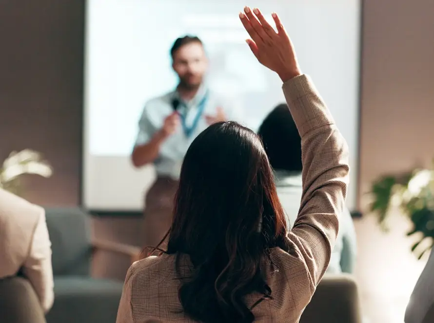 une employée lève la main pour participer à une formation sur l'éducation à l'environnement